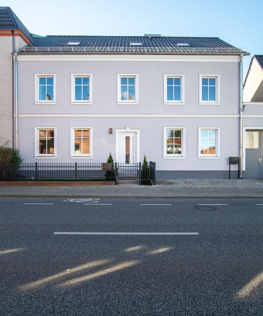 Stilvolles Zweifamilienhaus mit hellgrauer Fassade direkt an der Straße in Potsdam.