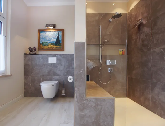 Gesamtübersicht eines Premium-Duschbads mit WC und Walk-In-Regendusche vom Handwerksunternehmen bad & heizung Laabs in Potsdam.