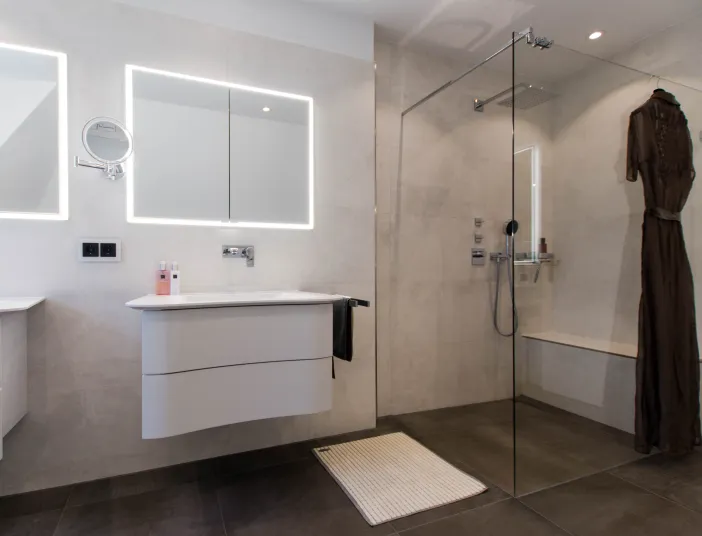 Walk-In-Dusche, Leuchtspiegel und Hängeschrank im Komplettbad vom Handwerksunternehmen bad & heizung Laabs in Potsdam.