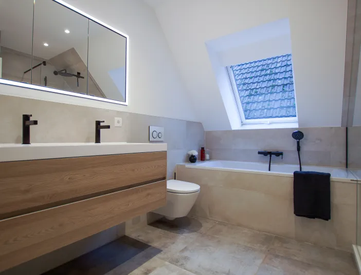 Großzügiges Badezimmer mit Dachschräge und Badewanne, Wand-WC und LED Lichtspiegel, Referenzbad von Laabs, Potsdam.