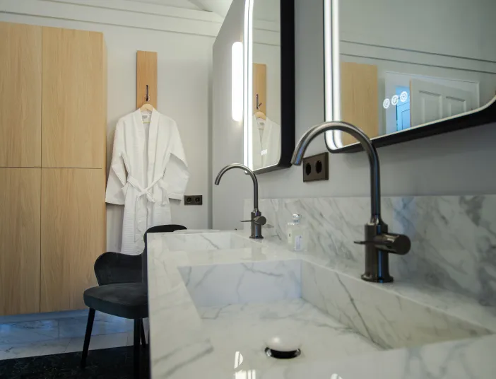 Nahaufnahme von einem Doppelwaschtisch in Marmoroptik mit zwei Stand-Einhebelarmatur aus der Serie VAIA von Dornbracht.